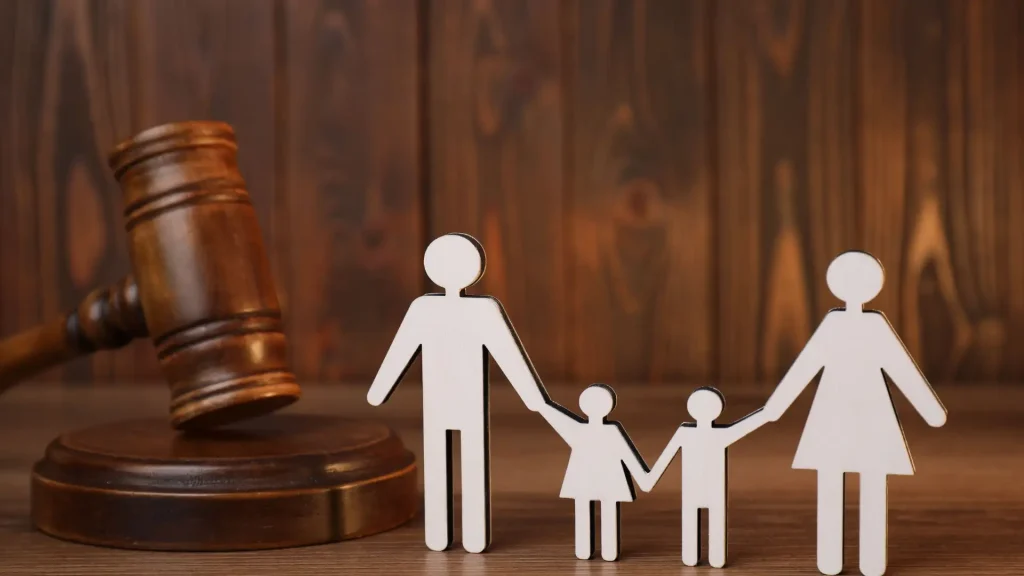 Family law concept—gavel and paper cutout family.