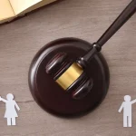 Judge’s gavel between male and female icons