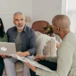 People having a discussion at home with a laptop and documents